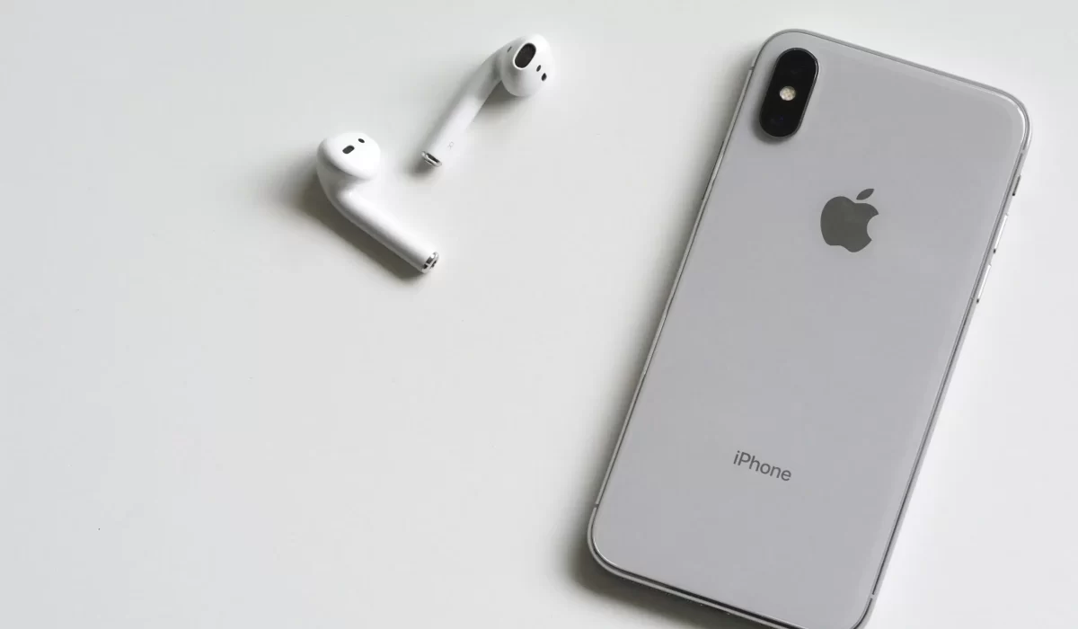 Apple phone and apple earbuds on a table